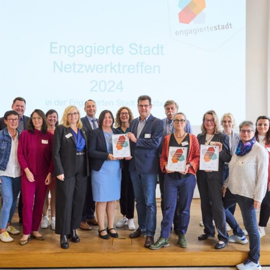 Foto vom Netzwerktreffen von Gruppe mit Landesvertrag mit Ekin Deligöz (parlamentarische Staatssekretärin), Hilmar Holzner (Bayerisches Staatsministerium für Familie, Arbeit und Soziales), Gabi Schmidt (Ehrenamtsbeauftragte Freistaat Bayern), Claudia Leitzmann (LBE Bayern), Beatrix Hertle (lagfa Bayern), Daniela van Wyk (BMFSFJ), Dr. Lilian Schwalb (BBE), Andreas Grau (Bertelsmann Stiftung), Frank Strathmann (Engagierte Stadt Holzkirchen), Daniela Schulte (Engagierte Stadt Puchheim), Sabine Nuber (Engagierte Stadt Kronach), Anna Lehrer (Engagierte Stadt Neumarkt), Judith Himmler (Engagierte Stadt Neumarkt), Wibke Limmer (Engagierte Stadt Würzburg), Cyana Pompeo Schuster (Engagierte Stadt Würzburg), Kristin Funk (Engagierte Stadt Würzburg)